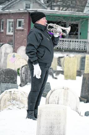 Ann Erickson blows taps.