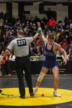 Spencer Stewart's hand is raised in victory as he secures his spot to compete at the State Championships.