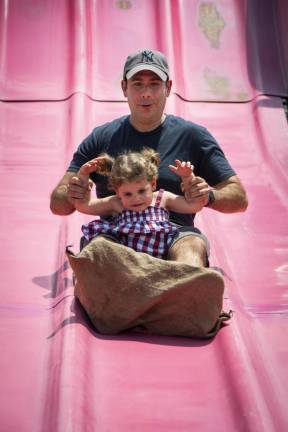 Paul Turchioe of Sparta and his daughter Millie, 2, go down the Fun Slide. (Photo by John Hester)