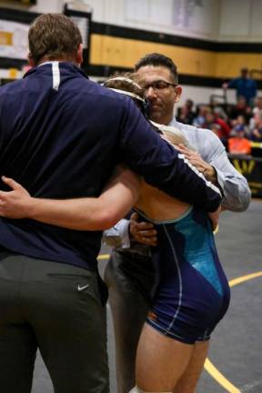 Troy Schmitzer leans against his coaches, John Procoppio and Frank Battaglia, after a challenging and exhausting match.