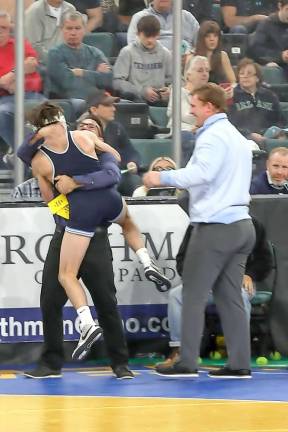 An exuberant Cooper Stewart jumps into the arms of Head coach Frank Battaglia after winning a very challenging match.