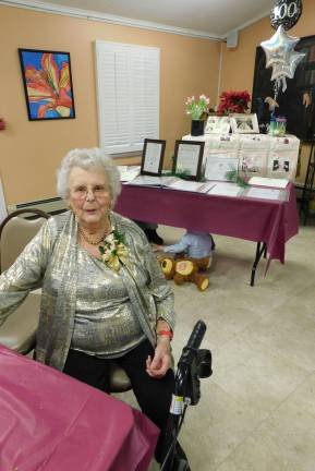 Florence "Flossie" Meyer poses in front of a table displaying her many achievements and accolades during a 100th Birthday Party in her honor on Saturday, Jan. 19, 2019, at the Walter Lynch Senior Center in Sparta. Playing under the table is the youngest party-goer, Meyer's 3-year-old great-grandson Gavin Healey DeMado. (Photos by Mandy Coriston).