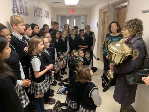 Project Self Sufficiency's Lisa Pagnos presents the Stuff the Stocking trophy to Pope John XXIII Middle School's leadership council on Thursday, Jan. 16, 2020, during a brief ceremony at Pope John XXIII Middle School in Sparta. Pope John XXIII Middle School won the trophy for the third straight year after donating a record 958 toys to Project Self Sufficiency's sixth annual toy drive competition.