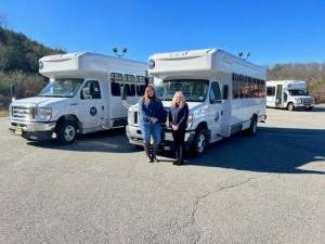 Sussex County Commissioner Jill Space stands with Health and Human Services Administrator Christine Florio in front of two newly purchased busses for Skylands Ride.