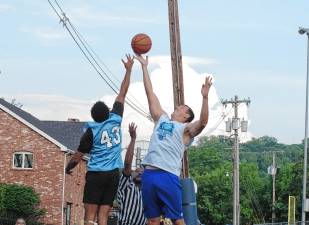 SB1 Team Falk's Ivan Hicks (43) and Team Smalley's Almin Hodzic reach for the ball during a tip-off to start the game. Team Smalley won the championship for the second year in a row, defeating Team Falk, 75-61. (Photo by George Leroy Hunter)
