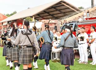 <b>Bagpipers march past Sussex County Miners players during a ceremony at the Battle of the Badges III on Aug. 15 at Skylands Stadium. (Photos by Maria Kovic)</b>