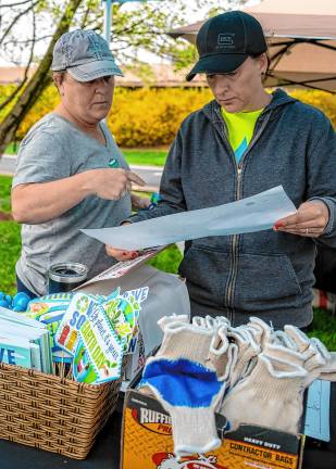 Kathy Romire and Amy Pecle look at a map of the cleanup area.
