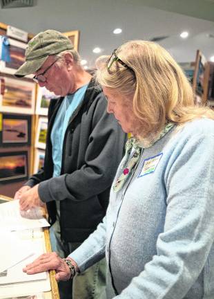 Mike Tracy and Linda Powers review club’s historical documents.