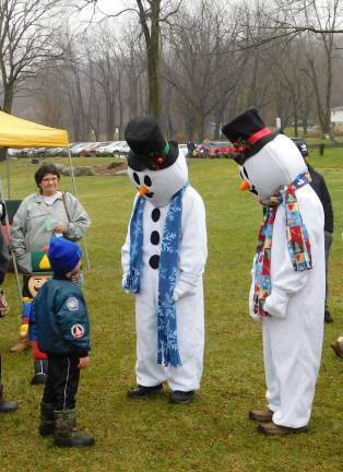 Snowmen greet a child at Sparta's Christmas Festival on Sunday Dec. 2, 2018 in Station Park. (Photo by Mandy Coriston).
