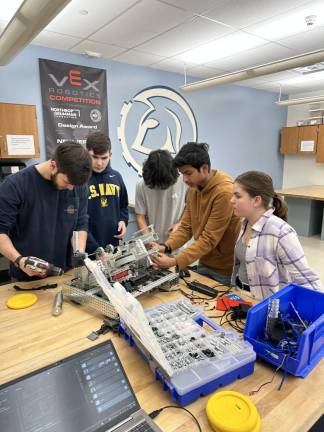 Members of team 5249 S “Zepherus” work on their robot. From left are Michael Ginsberg, mechanic; Nate Rogoff, driver/engineer; Josh Garces, mechanic; Manath Chintha, computer-assisted design programmer; and Laura Scheri, technical writer.