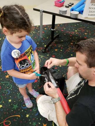 Emma and Donn Scales: Emma and her dad, Donn, put the finishing touches on their lightsaber.