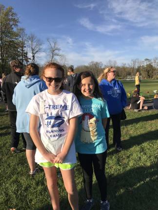 Brenna Philson, left, and Emily Fuchs attend different schools but know each other through the sport of running and were reunited at the Invitational.