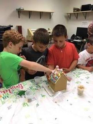 Kellen, Bret and Travis put finishing touches on their gingerbread house. photos provided