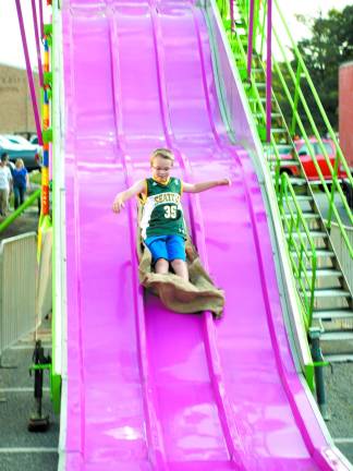 Ryan Clark, 9, of Sparta, lets gravity do all the work on the Giant Slide Friday night.