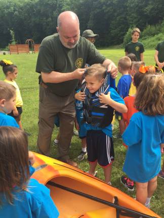 The kids learn about the proper wear and fit of a life vest from Boy Scout Troop 150