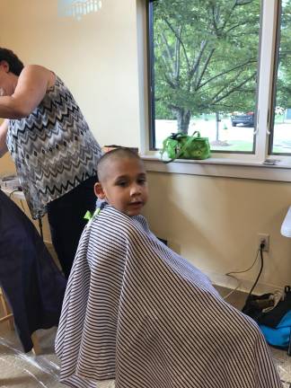 Anthony Cruz smiles during his free hair cut at the Back-To-School event.
