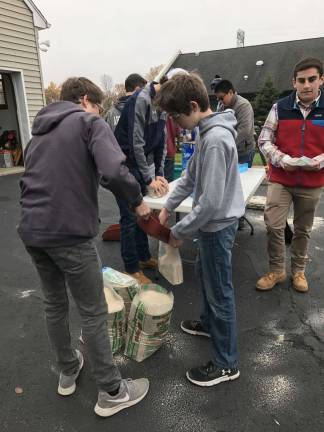 Squires Dan and Nick Furnari building Luminary sandbags along with Conor Armstrong, Carter Higgins, Fern Gomez, and Jack Lubertazzi