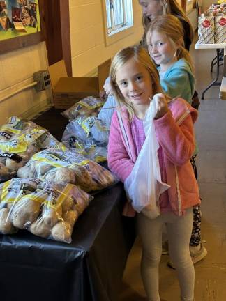 The daughters of Jennifer and Patrick Ellis do their part at the Goshen Ecumenical Food Pantry. Photo courtesy of Susan Armistead.