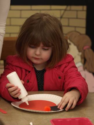 Lisa P., 3, of Sparta works on her Elmo puppet.
