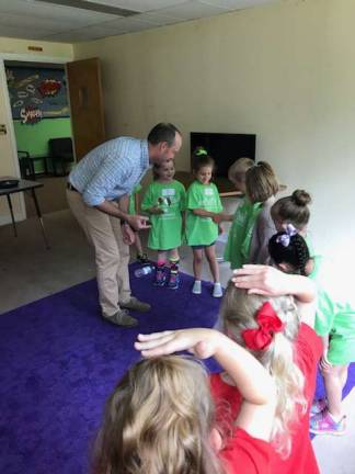 Dr. Chris from Wellness Pediatrics shows the kids how germs are passed around