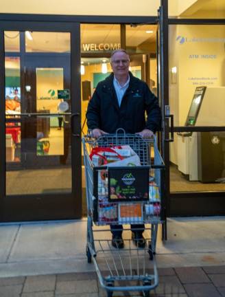 ST4 Keith Niedelgal of Hamburg, senior vice president/regional administrator at Lakeland Bank, pushes a shopping cart full of food.