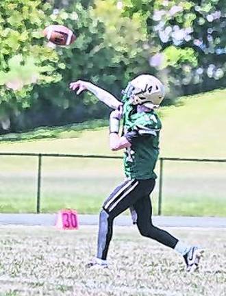 Sussex Tech quarterback Joey Scarpone throws the ball while his teammates hold back opponents.