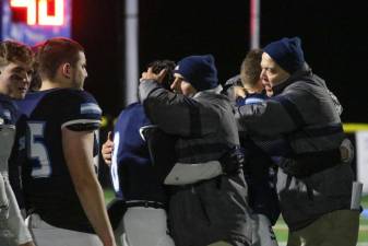 Sparta coaches hug team members one at a time after the final game of the season.