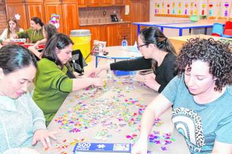 Teams race to complete a 500-piece jigsaw puzzle in the Puzzle-Palooza sponsored by the Sparta Parks &amp; Recreation Department. (Photos by Maria Kovic)