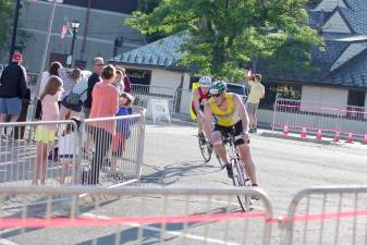 A cyclist rounds a corner at a previous Pass It Along Triathlon event.