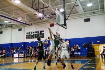 Basketball players battle for a rebound during the Pope John/Delbarton playoff game.