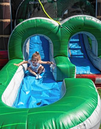 Aurora Geary plays on an inflatable slide.