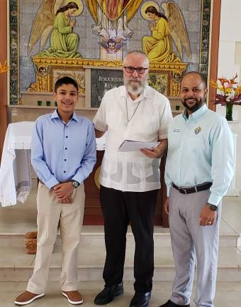 Father Oscar Rivera the head abbot of the Monastery of San Antonio Abad stands with Marco Lebron-Sanabria (left) and his father Juan following presentation of the donation and letter from the Saint Kateri Squires circle in Sparta, New Jersey.