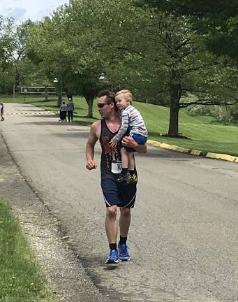 Mike Passafaro, of Fredon, got a little extra weight as he ran toward the finish. His son, Chase, greeted him to be carried at the end of the final loop. Photos by laurie Gordon
