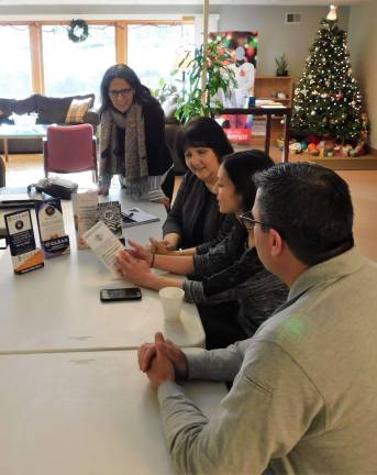 1- (Front to back) Newton Police Chief Mike Richards, C.L.E.A.R. recovery coach Katie Calvacca, Center for Prevention and Counseling Director Becky Carlson, and C.L.E.A.R. recovery coach Annmarie Shafer look over designs for brochure holders for program literature, at a meeting on Monday, Dec. 17. 2018. The prototypes were made by graphic design students at S.C.C.C.  2- C.L.E.A.R. recovery coaches Katie Calvacca (L) and Annmarie Shafer (R), and Newton Chief of Police Mike Richards discuss the program's mission and progress during a meeting on Monday, Dec. 17, 2018 at the Center for Prevention and Counseling.  (Photo by Mandy Coriston).