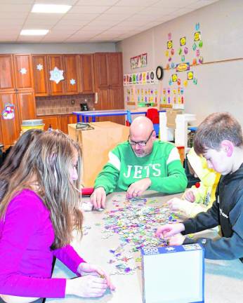 Teams race to put together a 500-piece puzzle Thursday, Feb. 22.