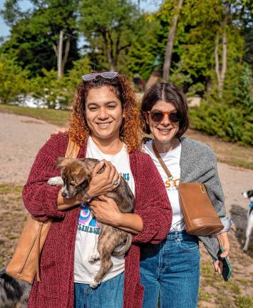 Lucy Dunn holds a pup waiting for adoption with Jess Cind of One Step Closer Animal Rescue (OSCAR).