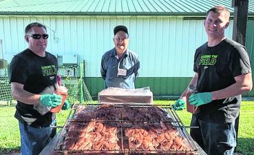 <b>Art Fetzer and sons help prepare the barbecue.</b>