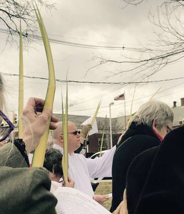 Attendees raised their palms in commemoration of Jesus entering Jerusalem