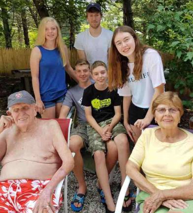 Judge Weber and his wife, Patricia, with their five grandchildren, where the Judge loved to be, by the pool.