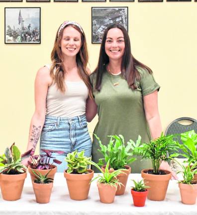 Lindsey Brown of Rooted Yoga and Melissa wright of Rooted by Wrights pose behind plants.