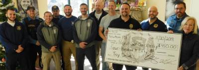 Bearded Newton Police Officers present Project Self-Sufficiency Executive Director Deborah Berry-Toon (R) with a check to be put toward the agency's Season of Hope Toy Drive on Saturday, Nov 30, 2019. The department contributed extra money during No-Shave November to be able to have Double Down December. The policemen earned the privilege of keeping their facial hair for another month while raising $450 for PSS.