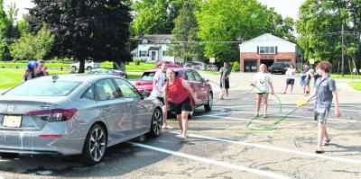 Members of the Marching Spartans wash a car.