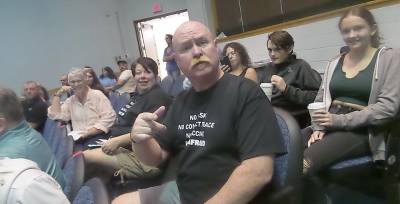 People without masks were asked to sit on the right side of the high school auditorium during the meeting. Several unmasked attendees wore tees that said, NO MASK, NO CONTACT TRACE, NO VACCINE, NOT AFRAID. (Photo by Frances Ruth Harris)