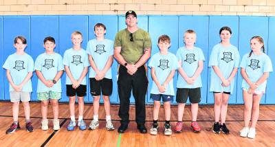 Office Brian Gallagher poses with Junior Police Academy participants.
