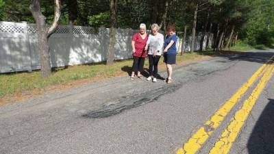 Joyce VanNest, Helga Becking and Gail Darcy point to one of the many sections of disappearing Sawkill Road (Photo by Frances Ruth Harris)