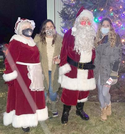Nikki Morville-Brand and her sister, Meredith Morville-Riley pose with Mr. &amp; Mrs. Claus. Despite Covid, the annual tree lighting in memory of their mother went on this year.