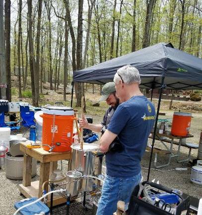 Homebrewers Rob Giaquinta and Paul West share a laugh as Giaquinta prepares a batch of mash for brewing.