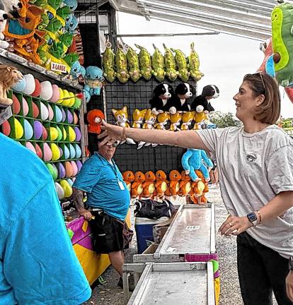 <b>A fair-goer tries her luck with darts Saturday, Aug. 2. (Photo by Denise von Wilke)</b>