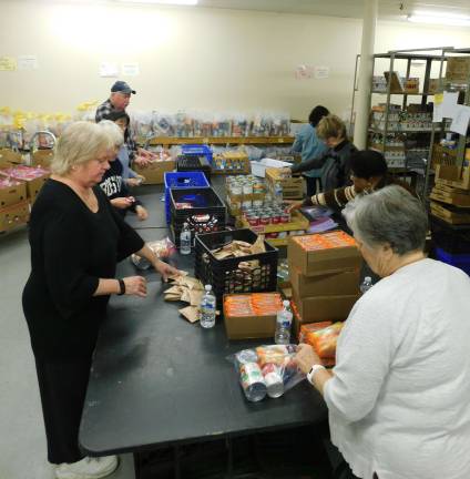 Volunteers from the Panther Valley Ecumenical Church pack "weekend bags" at the Sussex County Food Pantry on Thursday, Jan. 17, 2019. The bags are distributed to four local school districts to help food insecure students fill the food gap between meals at school. (Photo by Mandy Coriston).