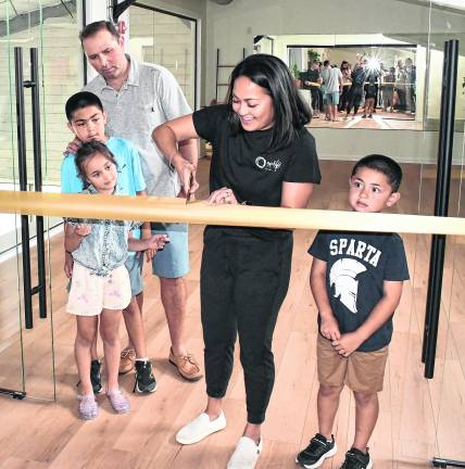 Rebecca Sarnicola of the Sparta Wellness Collective cuts the ribbon as her family looks on.